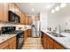 Modern kitchen boasts stainless steel appliances, granite countertops, and wood cabinets providing ample storage space at 5836 S Vivian Way, Littleton, CO 80127