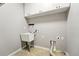 Functional laundry room features overhead cabinets, sink, and tiled floor at 5836 S Vivian Way, Littleton, CO 80127