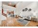 Open-concept living space with hardwood floors, tall ceilings, and a combined living, dining, and kitchen area at 5836 S Vivian Way, Littleton, CO 80127