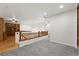 An open carpeted loft area features hardwood railings offering views of the downstairs and providing versatile space at 5836 S Vivian Way, Littleton, CO 80127