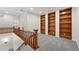 A carpeted loft area with hardwood railings and built-in shelves provides a versatile living space upstairs at 5836 S Vivian Way, Littleton, CO 80127
