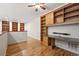 Spacious office area with custom wooden shelving, built-in desk, hardwood floors, and lots of natural light at 5836 S Vivian Way, Littleton, CO 80127