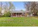 Spacious backyard with a covered patio, outdoor seating, and lush green lawn for relaxing and entertaining at 3379 W Wagon Trail Dr, Englewood, CO 80110