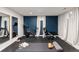 Finished basement with home gym featuring updated blue accent wall, mirrored wall, and fitness equipment at 3379 W Wagon Trail Dr, Englewood, CO 80110