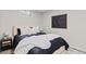 Bedroom boasts a plush bed with black and white linens, complemented by sleek black nightstands and modern art at 3379 W Wagon Trail Dr, Englewood, CO 80110