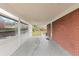 Spacious carport area with brick walls, white ceiling, and open view to the backyard of the home at 3379 W Wagon Trail Dr, Englewood, CO 80110