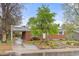 Beautiful home featuring solar panels, a brick exterior, attached carport, and lush front yard landscaping at 3379 W Wagon Trail Dr, Englewood, CO 80110