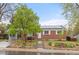Charming brick home with well-maintained landscaping, a beautiful tree, and solar panels on the roof at 3379 W Wagon Trail Dr, Englewood, CO 80110