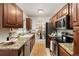 Traditional kitchen with granite counters, wood cabinets, and stainless steel appliances at 3379 W Wagon Trail Dr, Englewood, CO 80110