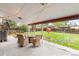 Cozy covered patio featuring a table and wicker chairs overlooking the spacious backyard at 3379 W Wagon Trail Dr, Englewood, CO 80110
