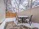 Snowy backyard patio featuring an outdoor dining set and a wood fence at 16390 E Radcliff Pl # B, Aurora, CO 80015