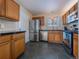 Charming kitchen featuring stainless steel appliances, wooden cabinetry, and stylish hexagon-shaped tile flooring at 16390 E Radcliff Pl # B, Aurora, CO 80015