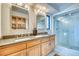 Bright bathroom featuring a double vanity, wood cabinets, and a glass-enclosed shower at 330 Ptarmigan St, Golden, CO 80403