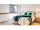 Bright bedroom features a comfy bed with green decorative pillows and a throw blanket near the window at 330 Ptarmigan St, Golden, CO 80403