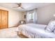 Cozy bedroom featuring carpet floors, neutral walls, bright window and a ceiling fan with white bedding at 330 Ptarmigan St, Golden, CO 80403