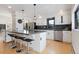 Modern kitchen with white cabinets, stainless steel appliances, island with bar seating, and dark backsplash at 330 Ptarmigan St, Golden, CO 80403