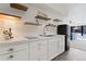 A well-lit kitchenette with stainless steel sink, modern appliances, floating shelves, and white cabinetry at 330 Ptarmigan St, Golden, CO 80403