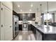 Modern kitchen with dark cabinetry, granite countertops, and stainless steel appliances at 9091 E 59Th North Pl, Denver, CO 80238