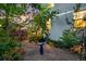 Serene backyard garden with lush greenery, a bird bath, and ambient lighting at 3240 Spruce St, Denver, CO 80238