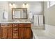 Well-lit bathroom with a double sink vanity, granite countertops, and a soaking tub with towel rack at 3240 Spruce St, Denver, CO 80238