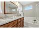 Bright bathroom featuring double sinks, granite countertops, and a soaking tub with natural light at 3240 Spruce St, Denver, CO 80238