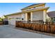Charming home featuring a two-car garage, latticed porch, and attractive wood fence at 3240 Spruce St, Denver, CO 80238