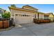 Side view of a tan home featuring a two-car garage and attractive wood fence at 3240 Spruce St, Denver, CO 80238