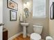 Stylish powder room features a pedestal sink, round mirror, and framed artwork at 3240 Spruce St, Denver, CO 80238