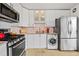 Kitchen featuring modern appliances, granite countertops, and a washer/dryer at 800 N Washington St # 710, Denver, CO 80203