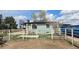 View of backyard with sports court, lawn area, garden, fence, utility dumpster, and patio, perfect for outdoor enjoyment at 15600 E 33Rd Pl, Aurora, CO 80011