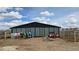 Exterior shot of a horse barn and surrounding equipment, showing the property's functionality at 15600 E 33Rd Pl, Aurora, CO 80011