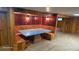 Basement dining area featuring wood paneling, booth seating, and unique light fixtures at 15600 E 33Rd Pl, Aurora, CO 80011