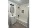 Renovated bathroom featuring a sleek vanity, a tiled shower-tub combo, and modern black fixtures at 15600 E 33Rd Pl, Aurora, CO 80011