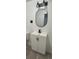 Updated bathroom showcasing a stylish vanity with a black faucet and a sleek, oval mirror at 15600 E 33Rd Pl, Aurora, CO 80011