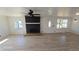 Inviting living room with cozy stone fireplace, new flooring, and many windows at 15600 E 33Rd Pl, Aurora, CO 80011