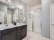 Bathroom featuring double sinks, quartz countertops, and a glass shower at 22466 E Layton Cir, Aurora, CO 80015