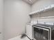 Bright laundry room featuring washer and dryer, and storage shelves at 22466 E Layton Cir, Aurora, CO 80015