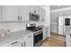 Modern kitchen with granite countertops, white cabinetry and stainless steel appliances at 13389 Amber Sky St, Parker, CO 80134