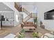 Inviting living room with soaring ceilings, a wooden staircase, and a stylish seating arrangement at 13389 Amber Sky St, Parker, CO 80134