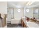 Bathroom with double sinks, bathtub, and natural light from decorative windows at 11274 W 54Th Ln, Arvada, CO 80002