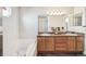 Bright bathroom with a double vanity, granite countertop, and a tub at 11274 W 54Th Ln, Arvada, CO 80002