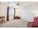 Neutral bedroom featuring a ceiling fan, carpet, window with blinds, and a comfortable rocking chair at 11274 W 54Th Ln, Arvada, CO 80002