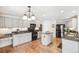 Well-lit kitchen with wood floors, island, gray cabinets and modern appliances at 11274 W 54Th Ln, Arvada, CO 80002