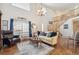 Bright living room with hardwood floors, a grand chandelier, and an open staircase at 11274 W 54Th Ln, Arvada, CO 80002