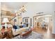 Bright living room with hardwood floors, a grand chandelier, and an open staircase at 11274 W 54Th Ln, Arvada, CO 80002