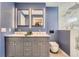 Bathroom featuring blue walls, a double sink, a toilet, and a shower at 1599 S Telluride St, Aurora, CO 80017