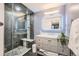 Updated bathroom featuring glass-enclosed shower, stone details, and modern vanity at 1599 S Telluride St, Aurora, CO 80017