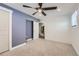 Cozy bedroom with gray accent wall, ceiling fan, and doorway to closet/bathroom at 1599 S Telluride St, Aurora, CO 80017