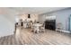 Open-concept dining area with a white round table, complementing chairs, a piano, and durable wood-look flooring at 1599 S Telluride St, Aurora, CO 80017