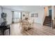 Well-lit dining area with a white table, wood chairs, a large window, and convenient access to the staircase at 1599 S Telluride St, Aurora, CO 80017